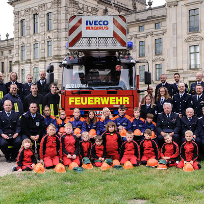 Bild vergrößern: Die Ludwigsluster Feuerwehr, die Jugendfeuerwehr und ein Feuerwehrauto mit Drehleiter posieren vor dem Schloß.